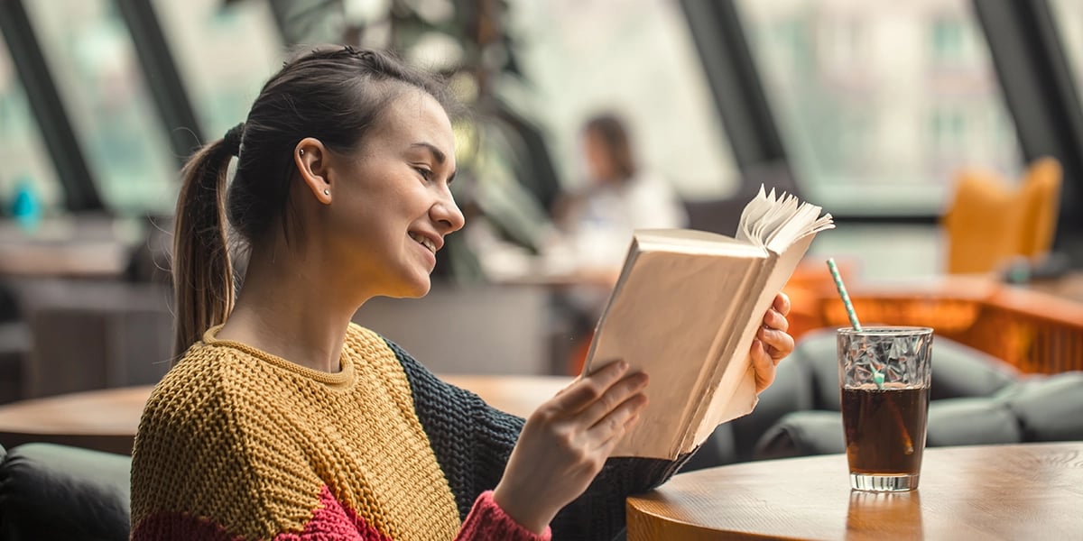 beautiful-young-woman-in-orange-sweater-reading-book-interesting-coffee